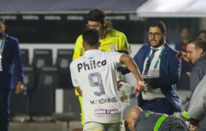 Marcos Leonardo, atacante do Santos, tenta ajudar o goleiro Cássio após sofrer uma agressão de um torcedor que invadiu o gramado